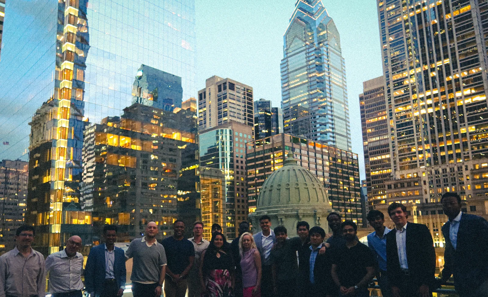 The oneprompt community on a rooftop with the Philadelphia skyline behind them